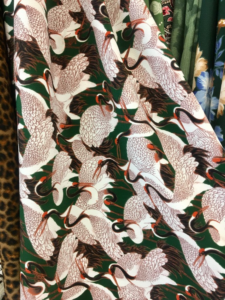 Green fabric with a crane print