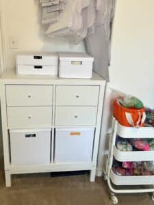 The same IKEA 4 shelf unit. The top 2 boxes have been replaced with drawers. The bottom boxes are no longer overflowing. The clutter on the top has been cleaned up and put into 2 boxes.