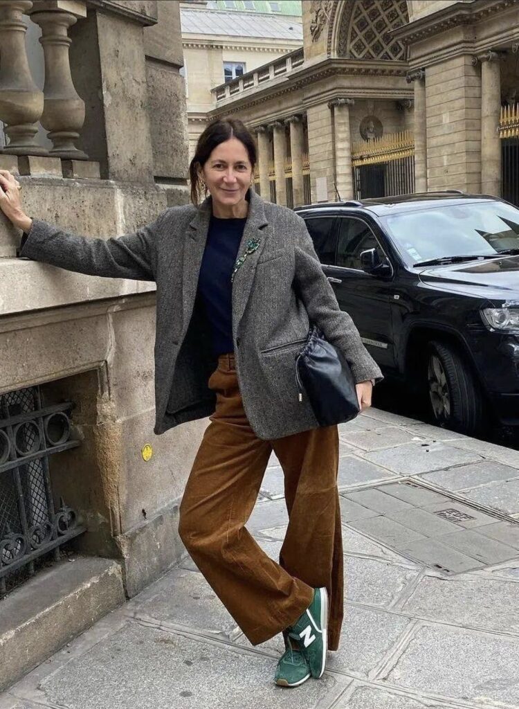 Street style portrait of a woman in a gray blazer and brown corduroy flared pants 
