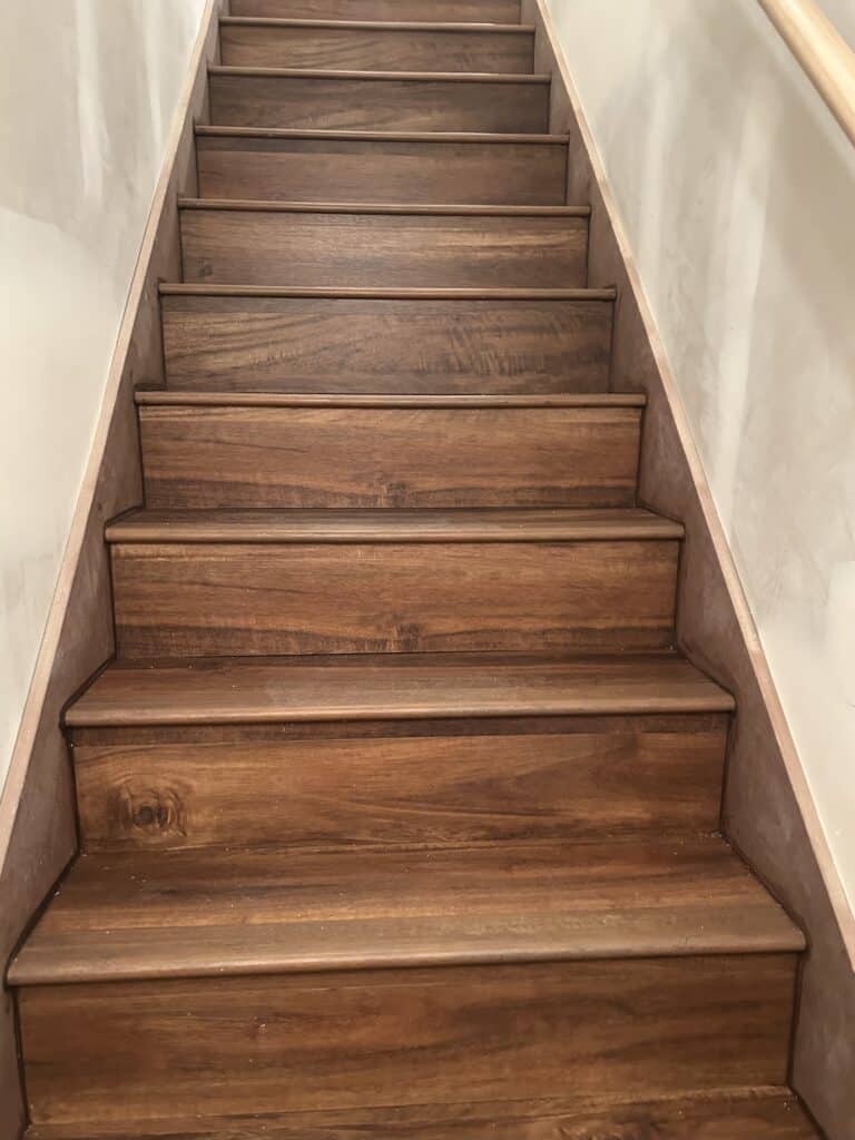 Looking up stairs covered in wood-look vinyl plank flooring. 