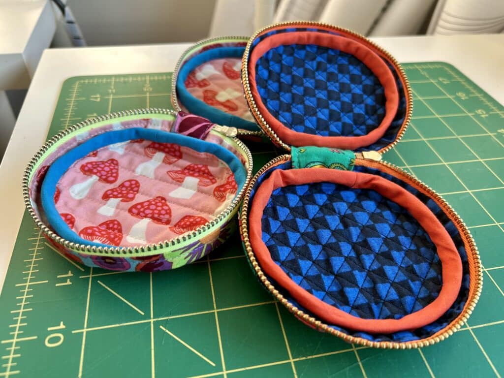 The two cases open. One has pink mushroom print lining and one has black and blue check lining. 