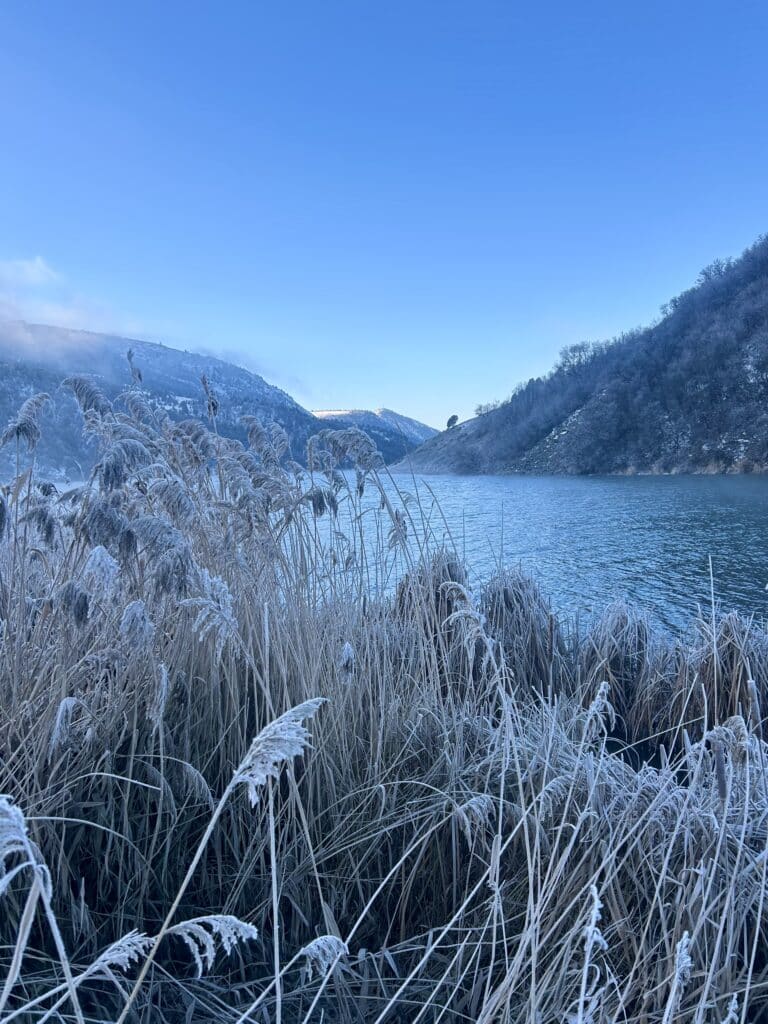 Morning on the river, with mountains on both sides and frost on all the river grasses