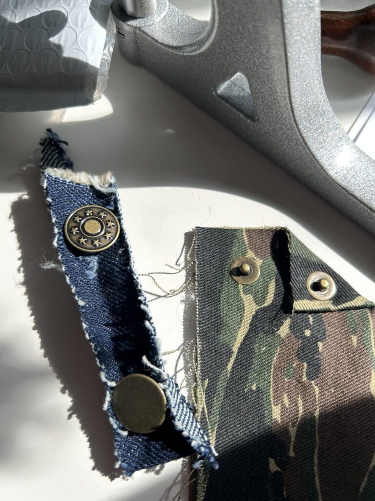 Two fabric scraps with test jeans buttons and test rivets installed