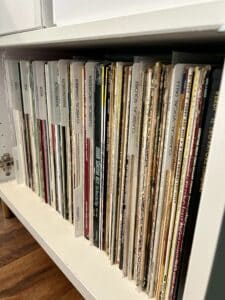 A cabinet of records, divided and labeled by genre and type
