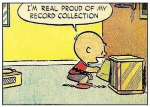 A panel from a Charlie Brown comic, where he's putting away a record and saying, I'm real proud of my record collection.