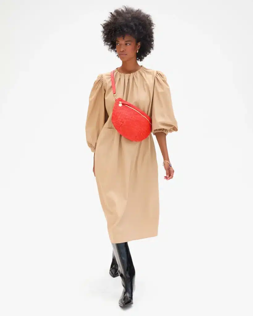 Screengrab of the Calre V site showing a model wearing a poppy red crossbody pouch