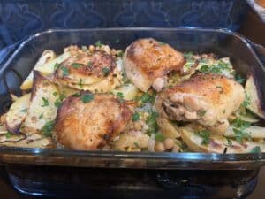 Roast chicken pieces on a bed of potatoes and garbanzos
