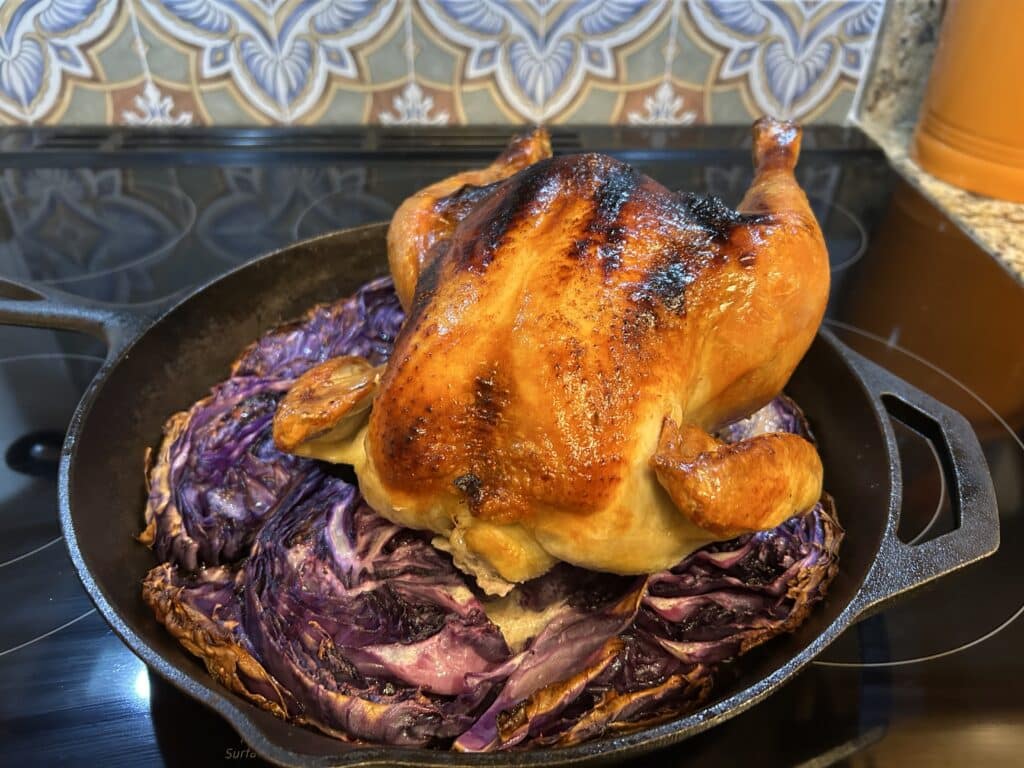 A roast chicken on a bed of purple cabbage