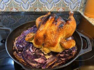 A roast chicken on a bed of purple cabbage
