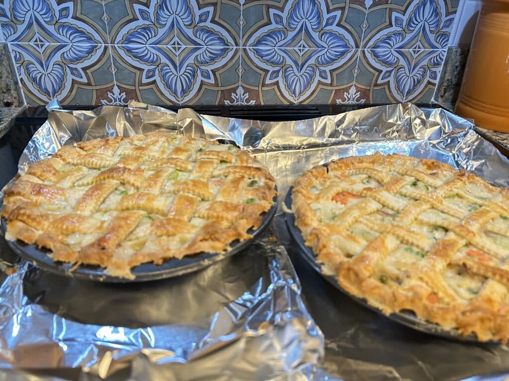 Two baked chicken pot pies on a sheet pan