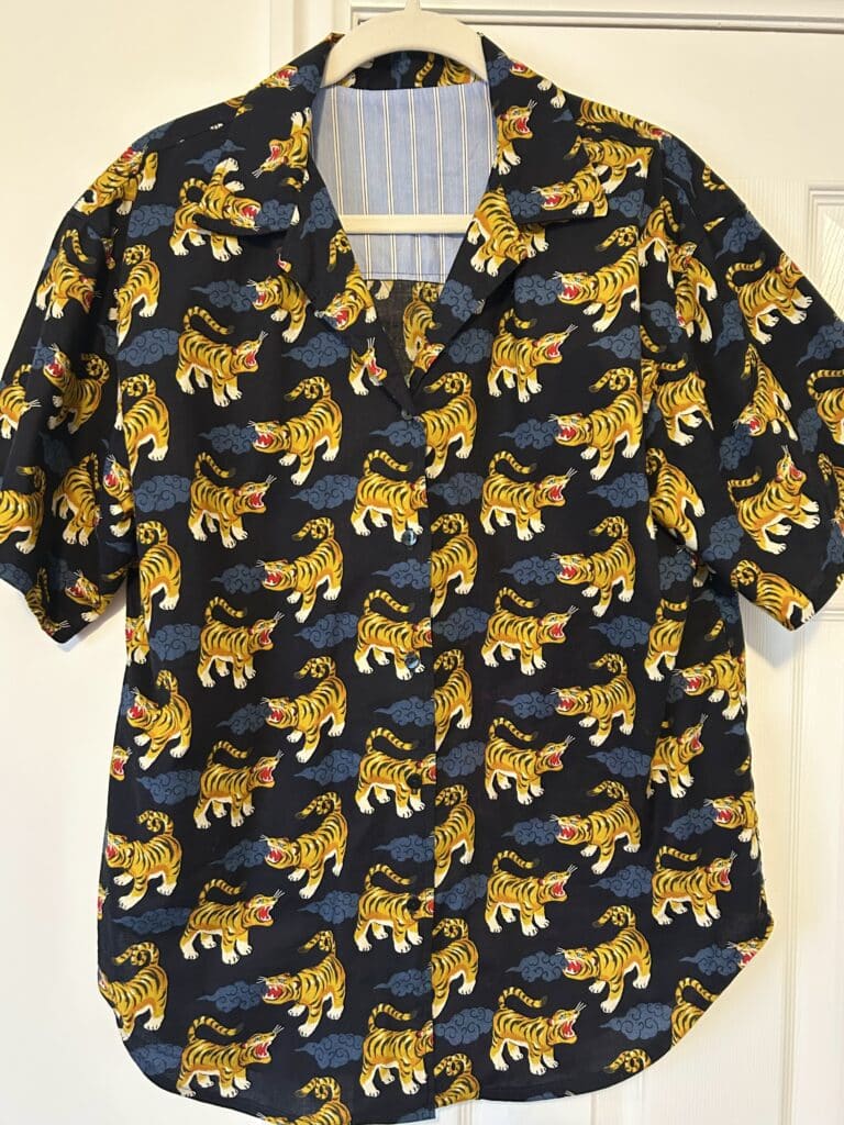 A navy blue short sleeve shirt with Japanese-style yellow tigers and blue clouds on it.
