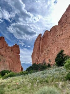 Tall red cliffs with blue mountains in the distance in Garden of the Gods