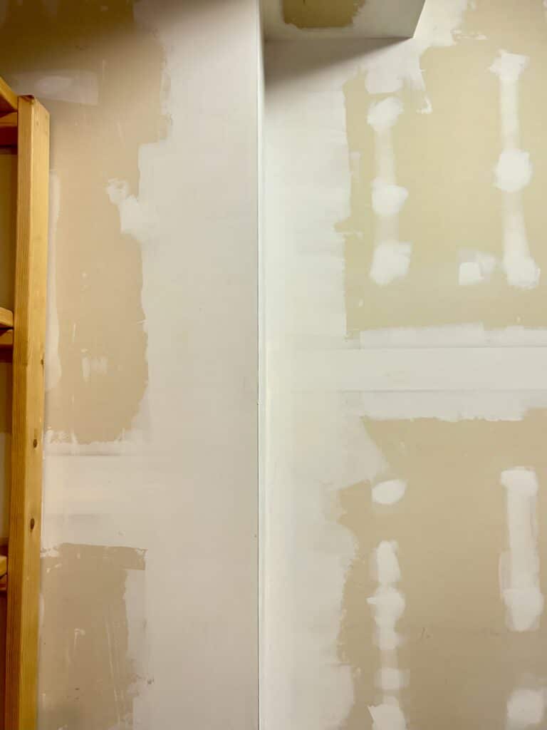 A close up of mudded and sanded walls in a corner of a garage 