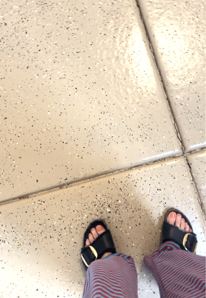 A woman's feet on a tan painted garage floor