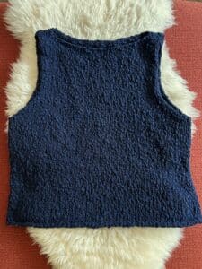 Flatlay of a navy knit boatneck sleeveless top in textured yarn.