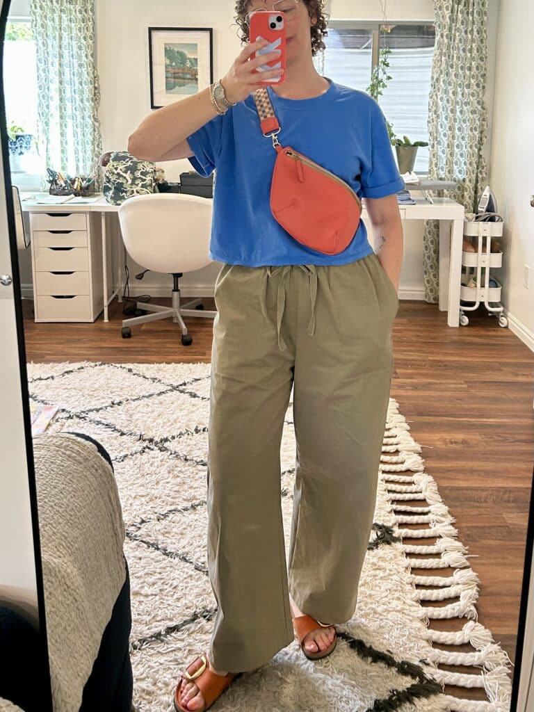 Mirror selfie of a woman in oversized olive drab drawstring pants and an oversized lapis blue t shirt. 